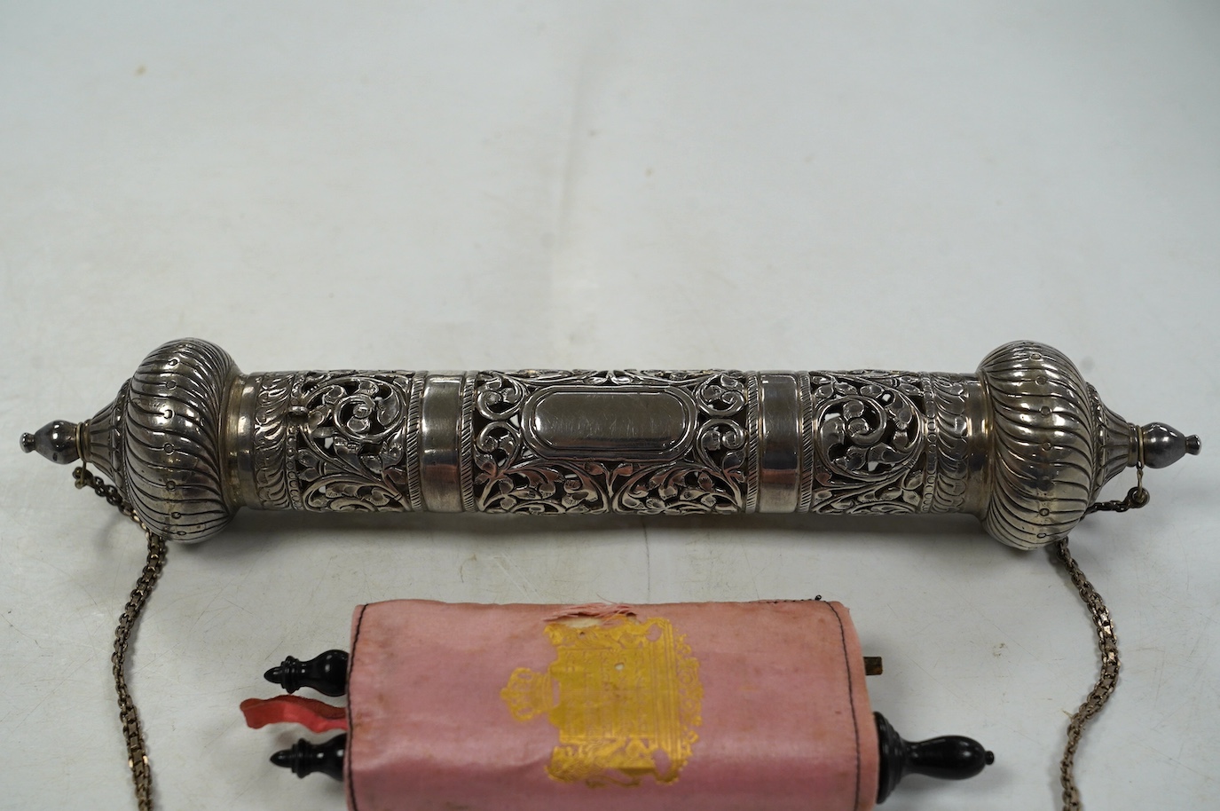 Two Judaica items, to include a pierced white metal scroll holder, 27cm and a miniature Torah portion scroll. Condition - poor to fair